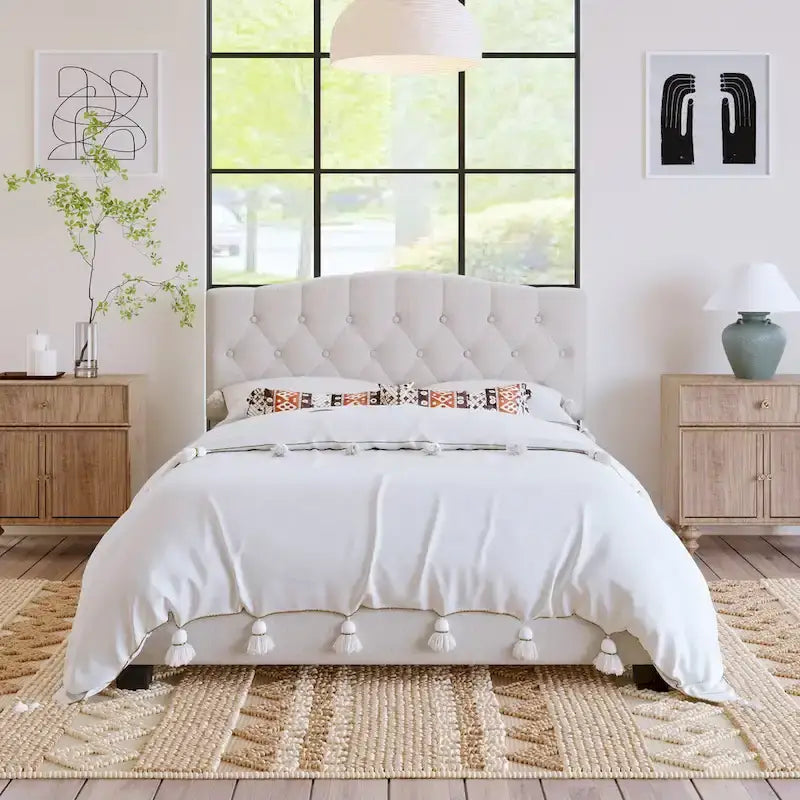 Cama de plataforma tapizada con cabecero curvado tipo silla de montar y detalles capitoné en forma de diamante